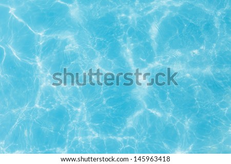 Swimming pool blue water surface with bright sun light reflections Royalty-Free Stock Photo #145963418