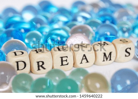 Bright gel multicolored balls next to the inscription: dreams. Festive picture. Abstraction. Shallow depth of field.