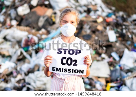 Woman Activist With Stop CO2 Emission Poster On Waste Dump. Recycle, Eco, Reuse Concept.