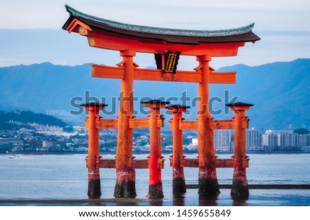 Image of the famous Torii Gate of Miyajima Island world heritage listed Shinto Shrine at Sunset with the tide just coming in, making it look like it is floating. (Translated text: Itsukushima Shrine)