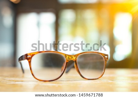 Brown glasses on wooden table. Eyeglasses at office for relaxation concept. Protection eyesight object.