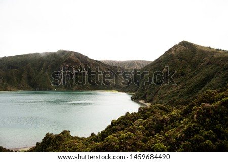 A sea surrounded by trees and forested mountains