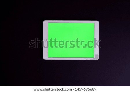 Table with green screen on the black background
