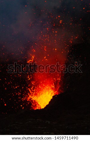 Dangerous fire and lava explosion at volcanic eruption in night
