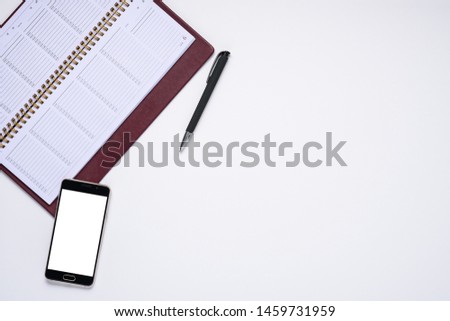 business composition. smartphone and notebook with pen on white background with copy space