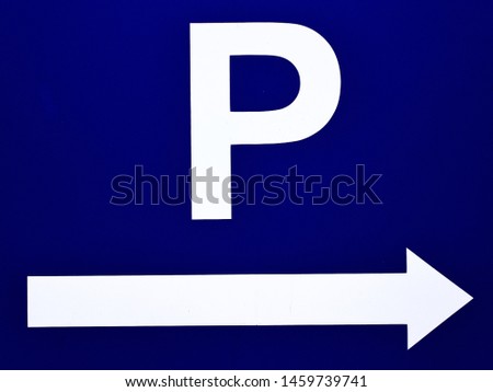 road sign indicating the direction to the parking lot