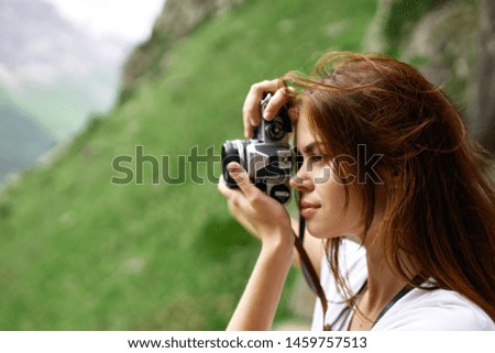 woman takes pictures in the mountains in nature