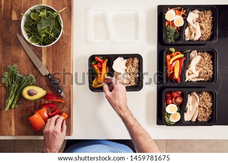 Overhead Shot Of Man Preparing Batch Of Healthy Meals At Home In Kitchen Royalty-Free Stock Photo #1459781675