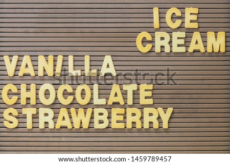 Vintage brown sign with the yellow text ice cream, vanilla, chocolate and strawberry
