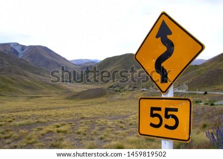 Traffic sign in New Zealand with reference to road with curves
