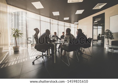 A team of young businessmen working and communicating together in an office. Corporate businessteam and manager in a meeting Royalty-Free Stock Photo #1459831610