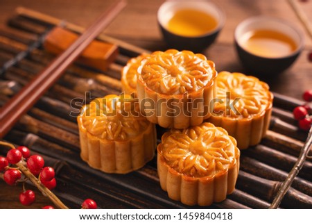 Moon cake Mooncake table setting - Round shaped Chinese traditional pastry with tea cups on wooden background, Mid-Autumn Festival concept, close up. Royalty-Free Stock Photo #1459840418
