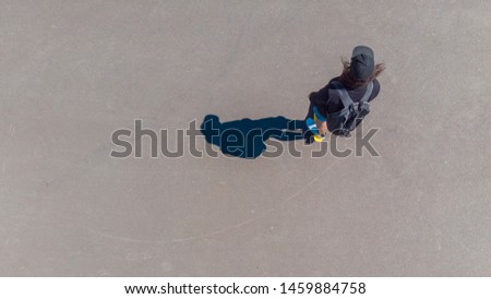 Guy rides a skateboard, top view, shadow on the pavement. Youth lifestyle, copy space on the left