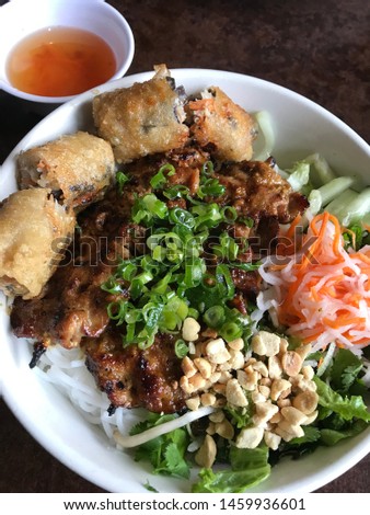 A bowl of Vermicelli Noodles with Grilled Pork and Egg Rolls Royalty-Free Stock Photo #1459936601