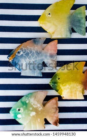 fish made of stone on a colored background 