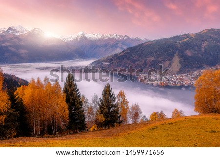 Incredible Nature Landscape., foggy morning during sunrise at Alpine lake in autumn. Colorful Sky over the Zeller Lake in Zell am See, Salzburger Land, Austria. Creative image. Natural Background