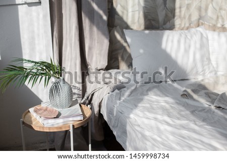 Beige bedroom with simple decor items in beach styled home apartment. Scandinavian interior. Minimalism.