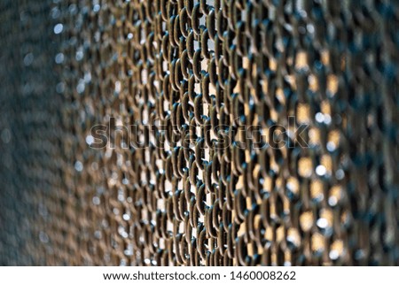 Close-up pictures of rust-colored chains which are hanging in the outdoor in natural sunlight and the original colors present the issue of obstruction.
