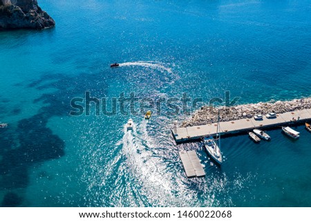 Aerial view of beautiful coastline with small boats and rocky seashore.