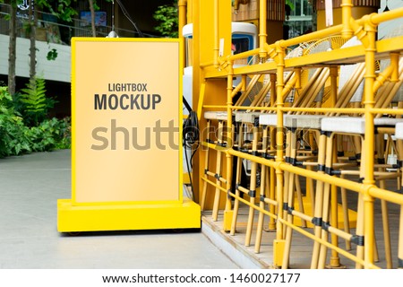 Mock up of yellow light box in a city for your advertising. Blank mock up of vertical street poster billboard for your text message or promotional content.