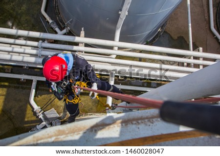Top view Male worker rope access height safety inspection of thickness storage oil and gas tank industry