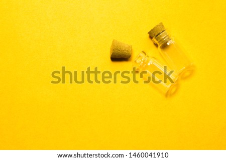 Empty little bottles with cork stopper isolated on yellow. glass vessels. transparent containers. test tubes. copy space