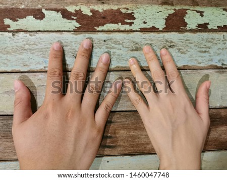 Hands of the lovers with close of their little figers on old wood table. Man & woman hands on the table.