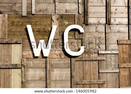 a wc sign with a background of vintage weathered wood