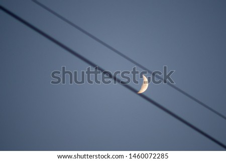 crescent moon and wires in the sky