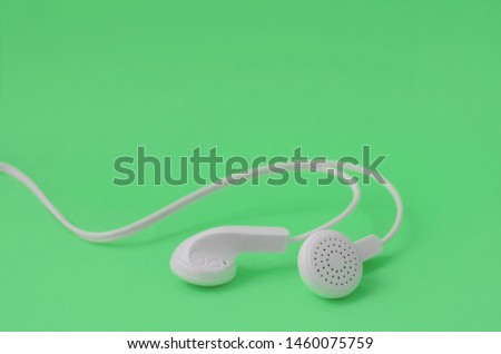 A template for music listening fans. White earphones on green