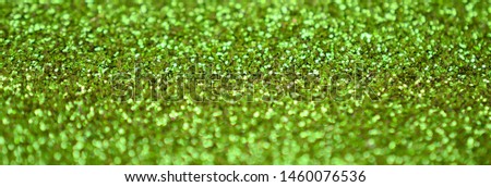 Lime green decorative sequins. Background image with shiny bokeh lights from small elements