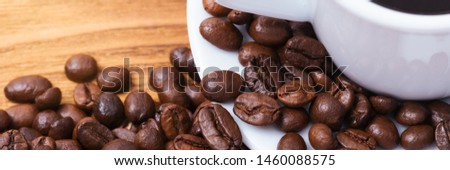 Coffee bean. On the background of wooden boards a cup of coffee and scattered coffee beans. Layout. Flat lay.