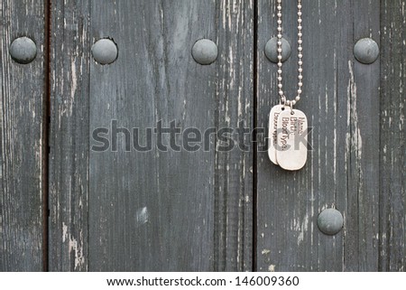 Dog tags hanging on old wood wall background