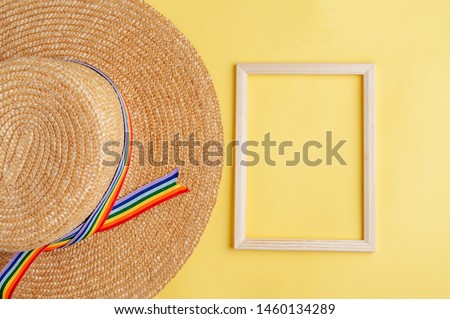 Summer composition. hat, photo frame, on yellow background. Summer concept. Flat lay, top view, copy space the concept of pride