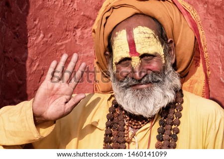 Sadhu man with traditional painted face in Pashupatinath Temple of Kathmandu, Nepal.Sadhu man refer to holy person.Nepal text in photo refer to prayer word om mani padme hum - Film grain effect Royalty-Free Stock Photo #1460141099