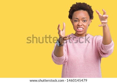 Beautiful young african american woman over isolated background Shouting frustrated with rage, hands trying to strangle, yelling mad