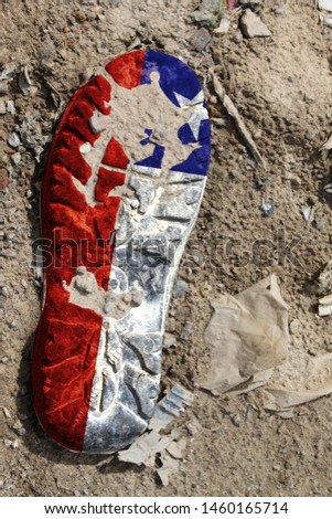 The flag of Chile is depicted on the sole of an old boot. Ecology concept with environmental pollution from household and industrial waste.