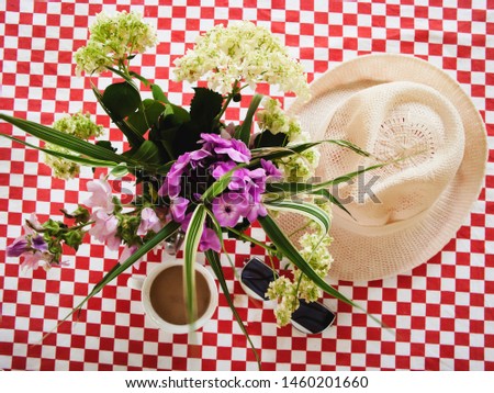 summer flowers hat coffee and sunglasses on a colorful background