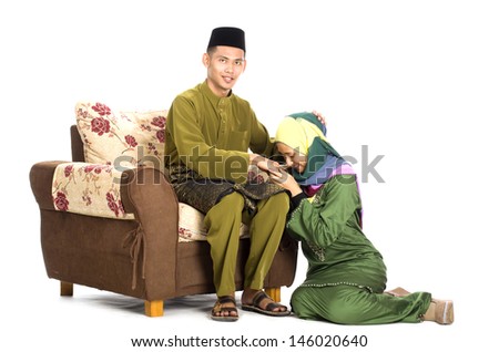 Husband and wife asking forgiveness during Eidul Fitri celebration.