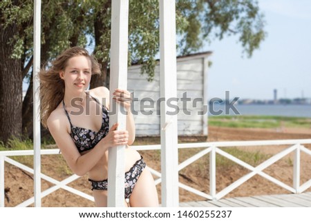 Young beautiful girl model, with white hair and white skin, in a swimsuit on the background of the beach and nature, with a place to write. The concept of outdoor recreation