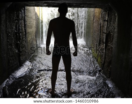the silhouette of a man in a dark tunnel. Goes to will