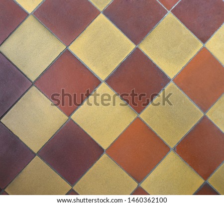 Background of old shabby uniform square ceramic floor tiles. Diagonal chequered pattern, top view. 