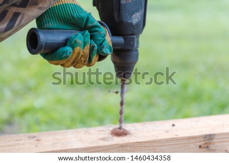 drill a hole in the board. Drill a hole in the timber. drill for wood.
