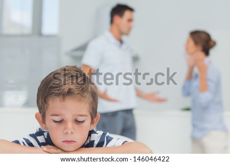 Sad boy while parents quarreling in the kitchen Royalty-Free Stock Photo #146046422