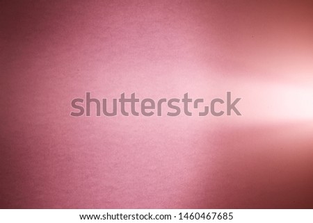 Light pink ray of light cuts through the pink textural and dark pink blurred background