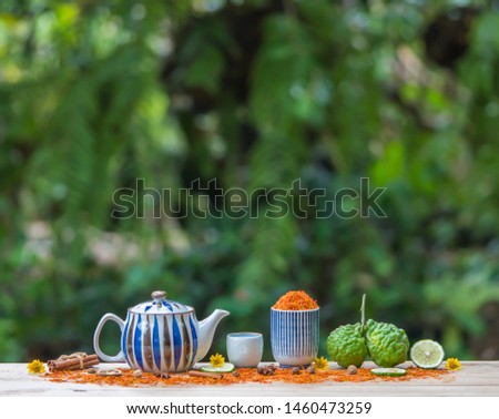 Herbal  organic  tea  from  various  herb  for  reduce  cholesterol  in  teapot  and  cup  on wood  table  with  nature  blurry  background