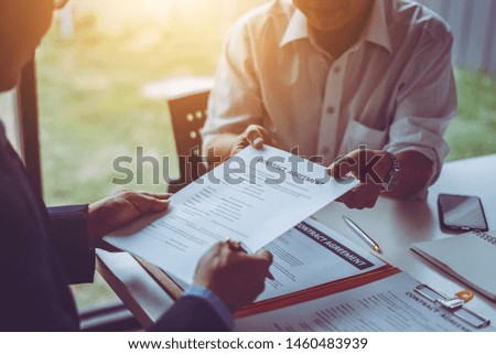 Group of middle age Asian business people and lawyers discussing and sign a contract in meeting room.