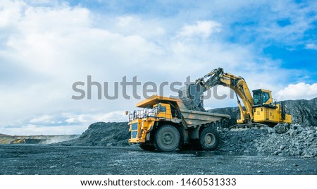 Work of trucks and the excavator in an open pit on gold mining, soft focus Royalty-Free Stock Photo #1460531333