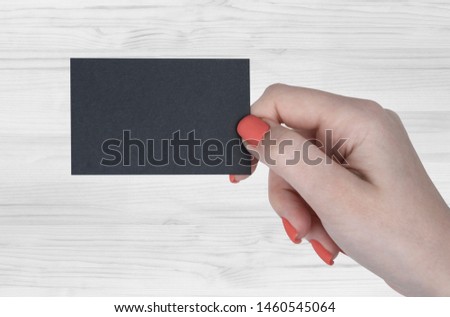 A woman hands holding a black business card