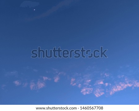 little cloud and small moon in blue sky